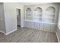 Bright room with built-in shelves and cabinets set in a brick frame with vinyl plank flooring at 159 Foxborough Rd, Goose Creek, SC 29445