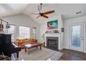Bright living room with high ceilings, a fireplace, hardwood floors, and a cozy leather sofa at 1728 Barracuda Rd, Johns Island, SC 29455