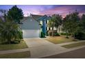 Charming two-story home showcasing a well-manicured lawn and inviting curb appeal at twilight at 1896 Palmetto Isle Dr, Mount Pleasant, SC 29466