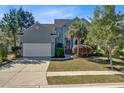 Beautiful two-story home with a lush lawn, mature trees, and a welcoming garage and driveway at 1896 Palmetto Isle Dr, Mount Pleasant, SC 29466