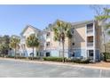 Multi-story condo building with a coastal aesthetic, featuring balconies, palm trees, and ample parking at 200 Bucksley Ln # 308, Charleston, SC 29492