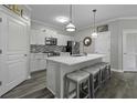 Bright kitchen featuring a center island with seating, white cabinets, modern appliances, and wood-look flooring at 200 Bucksley Ln # 308, Charleston, SC 29492