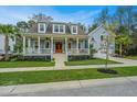 Inviting two-story home with a classic front porch, complemented by a well-maintained lawn and garden at 2415 Jasper Patterson Dr, Johns Island, SC 29455