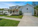 Charming two-story home featuring a welcoming front porch, manicured lawn, and an attached garage at 2415 Jasper Patterson Dr, Johns Island, SC 29455