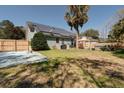 Spacious backyard featuring a wooden fence, grass yard, a utility shed and solar panels on the roof at 2612 Morning Dove Ln, Charleston, SC 29414