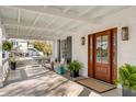 Inviting front porch featuring comfortable seating, a wood door, and decor creating a relaxing outdoor space at 2802 Ion Ave, Sullivans Island, SC 29482