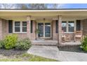 Inviting front porch with rocking chairs, brick columns, and a view of the landscaped yard at 303 Gippy Dr, Summerville, SC 29486