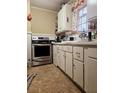Vintage kitchen featuring white cabinets, an oven, and a sink under the window at 306 Perry Rd, Walterboro, SC 29488