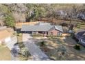 Aerial view of a brick home with mature trees, a driveway, and fenced yard at 313 Runnymede Ln, Summerville, SC 29485