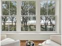 Living room view through large windows showcasing the waterfront and manicured gardens at 32 Prioleau St # N, Charleston, SC 29401