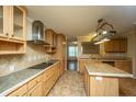 Spacious kitchen with island, stainless hood vent, tile backsplash, granite countertops, and light wood cabinets at 3596 Walter Drive Dr, Johns Island, SC 29455