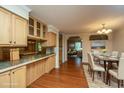 Open kitchen and dining area with wood floors, light wood cabinets, an island bar, and seating for six at 3596 Walter Drive Dr, Johns Island, SC 29455