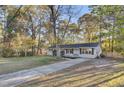 A view of the well maintained home with brick accents, lush lawn and mature trees providing nice shade at 402 Corey Blvd, Summerville, SC 29483
