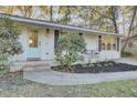 Charming front entrance featuring a light blue door, brick accents, lovely landscaping, and a cozy sitting area at 402 Corey Blvd, Summerville, SC 29483