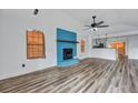 Bright living room featuring hardwood floors, a unique blue-tiled fireplace, and an open layout to the kitchen at 425 Miami St # A, Ladson, SC 29456