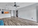 Open living room with hardwood floors, ceiling fan, neutral paint, and seamless transition to kitchen and hallway at 425 Miami St # A, Ladson, SC 29456