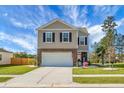 Beautifully landscaped two-story home featuring a spacious driveway, a two-car garage, and a charming front yard with lush greenery at 436 Blue Elderberry, Moncks Corner, SC 29461