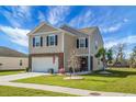 Inviting two-story home with a well-maintained lawn, stylish stone accents, and a convenient attached two-car garage at 436 Blue Elderberry, Moncks Corner, SC 29461
