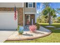 Inviting front entrance with stone accents, a well-manicured lawn, and a charming display of seasonal decorations and landscaping at 436 Blue Elderberry, Moncks Corner, SC 29461