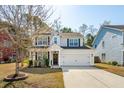 Traditional home featuring manicured landscaping, light gray exterior, black shutters and attached two car garage at 467 Nelliefield Trl, Wando, SC 29492