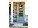Inviting entryway featuring a stylish teal door, stone accents, and a lantern, complete with visible house numbers at 523 Coaxum Rd, Mount Pleasant, SC 29464