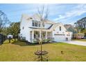 Beautiful home with a well-maintained lawn and landscaping, accentuated by a young tree in the front yard at 523 Coaxum Rd, Mount Pleasant, SC 29464