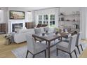 Open dining room with fireplace, shelving, table set for six and large window letting in natural light at 577 Red Monarch Way, Moncks Corner, SC 29461