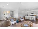 Open-concept living room featuring stylish furnishings, hardwood floors, and plenty of natural light at 579 Red Monarch Way, Moncks Corner, SC 29461