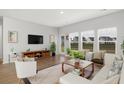 Cozy living room with large windows that offer ample natural light and views of the neighborhood at 588 Red Monarch Way, Moncks Corner, SC 29461