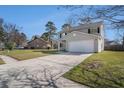 Two-story home features a long driveway, well-manicured lawn, and a two-car attached garage at 8005 Old Hazelwood Rd, North Charleston, SC 29406