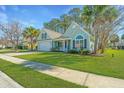 Charming home boasts a well-manicured lawn, attached garage, and lovely curb appeal with mature trees at 8502 Sentry Cir, North Charleston, SC 29420