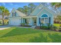 Charming home boasts a well-manicured lawn, attached garage, and lovely curb appeal with mature trees at 8502 Sentry Cir, North Charleston, SC 29420