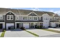 Attractive townhouse exteriors with two-car garages, manicured lawns and neutral-toned siding at 9712 Transplanter Cir, Ladson, SC 29456