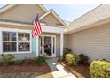 Inviting front entrance with American flag, wreath, and well-manicured landscaping, enhancing curb appeal at 1233 Bridgeport Dr, Mount Pleasant, SC 29466