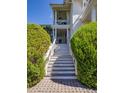 Inviting staircase leading to the elevated porch, framed by manicured greenery at 1302 Middle St, Sullivans Island, SC 29482