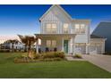 Charming two-story home features a manicured lawn, two-car garage, and a welcoming front porch at 1530 Homecoming Blvd, Ravenel, SC 29470