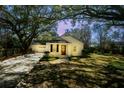 Inviting exterior of home featuring mature trees, a well-maintained lawn, and a driveway leading to the attached garage at 1637 Tatum St, Charleston, SC 29412