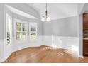 Bright dining room featuring hardwood floors, wainscoting, and ample natural light from large windows with modern shutters at 1810 Laura Creek Rd, Charleston, SC 29412