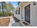 Inviting front entry with a dark blue door, and a charming hello mat at 202 Basswood Ave, Summerville, SC 29483