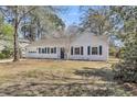 One story home with white painted brick, fresh landscaping, and blue shutters at 202 Basswood Ave, Summerville, SC 29483