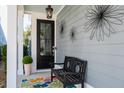 Inviting porch with a cozy bench, colorful rug, and decorative wall art at 2142 Oyster Reef Ln, Mount Pleasant, SC 29466