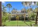 Charming exterior with double balconies, a screened porch, and beautiful tropical landscaping at 2440 Cat Tail Pond Rd, Seabrook Island, SC 29455