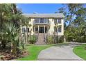 Welcoming front entrance features a brick staircase, a covered porch, and manicured landscaping at 2440 Cat Tail Pond Rd, Seabrook Island, SC 29455