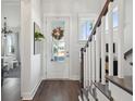 Bright foyer with wood floors, white staircase, and glass-paneled front door at 2545 Hatch Dr, Johns Island, SC 29455