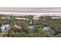 Aerial view showcases a beach house nestled amongst trees with beach access in the background at 263 Pelican Flight Dr, 15.4% Share, Dewees Island, SC 29451