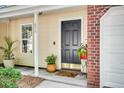 Close-up of a welcoming front door with red brick and plants to create an inviting entryway at 275 Kelsey Blvd, Charleston, SC 29492