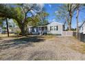 Charming one-story home with a small porch, grey siding, and a gravel yard at 2925 Alabama Dr, North Charleston, SC 29405
