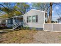 Charming grey home with a cozy front porch, black shutters, and green landscaping at 2925 Alabama Dr, North Charleston, SC 29405