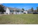Inviting single-story home with a covered porch and large grassy front yard at 3075 Old Highway 52, Moncks Corner, SC 29461