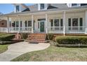Charming front porch with white columns, brick stairs, and manicured landscaping at 318 Archibald Dr, Goose Creek, SC 29445